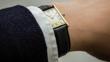 A wrist wearing a Cartier watch.