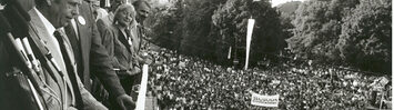 Havel stands on a balcony over a crowd of people.