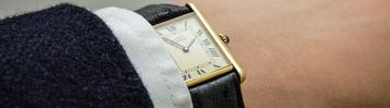 A wrist wearing a Cartier watch.
