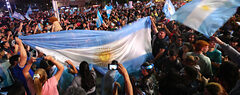 An Argentinian crowd waving flags in celebration of Milei's election.