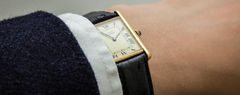 A wrist wearing a Cartier watch.